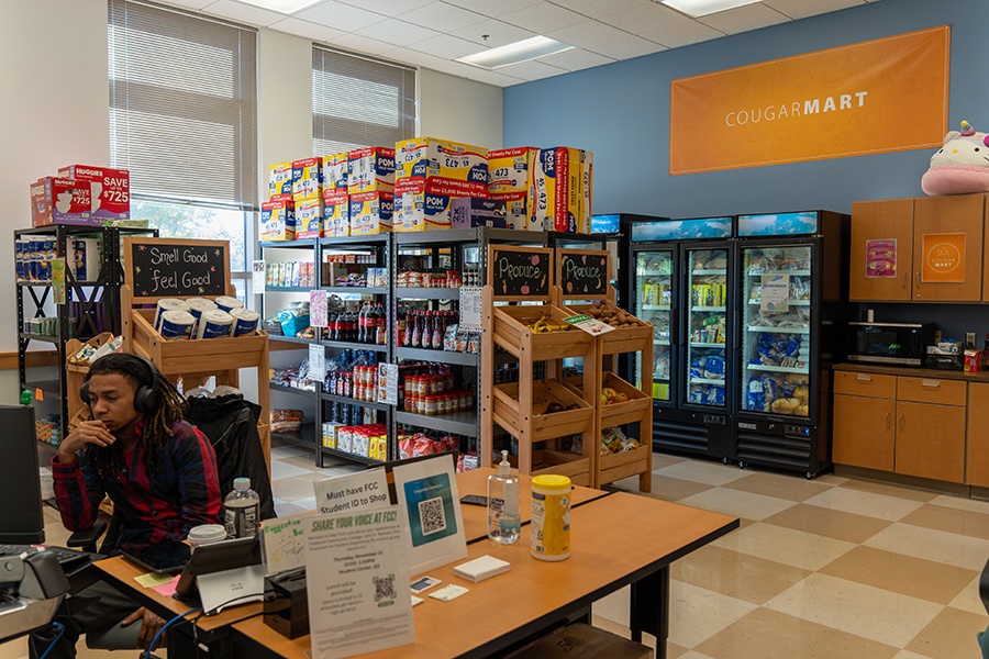 A compact campus convenience store stocked with snacks, drinks, paper products, and refrigerated food.